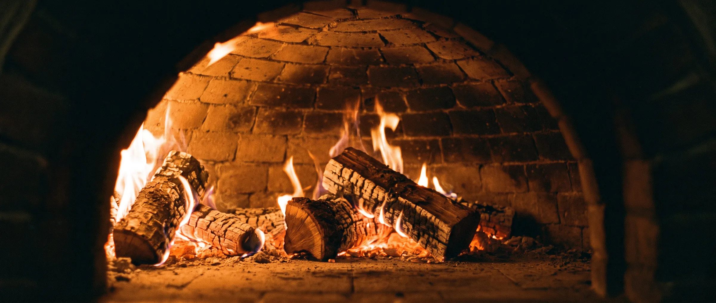 Oak logs burning inside the brick oven